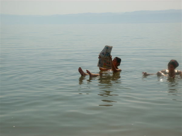 reading an arabic paper in the dead sea