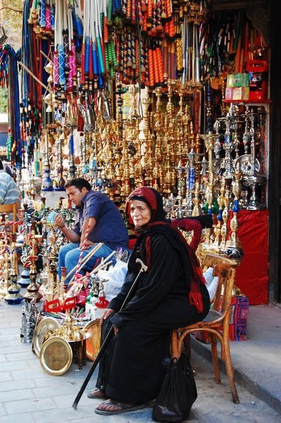 Vieille dame égyptienne devant un marchand de chichas