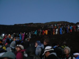the masses of people climbing mount fuji with us