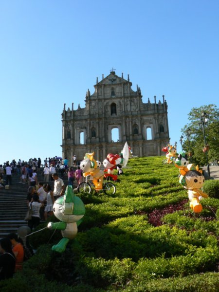 The ruins of St. Paul behind the olympic mascots