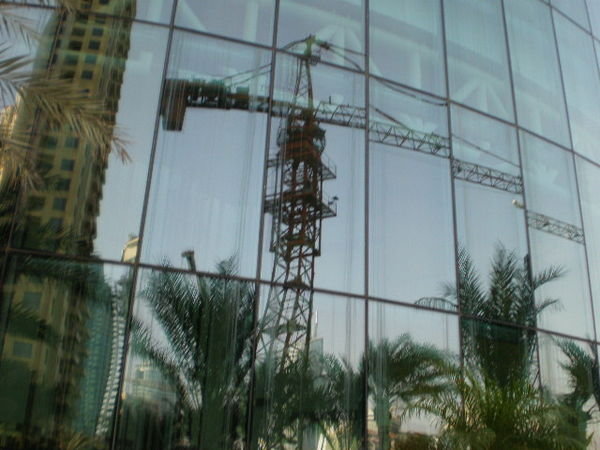 Reflection of a crane working right next to the pool.
