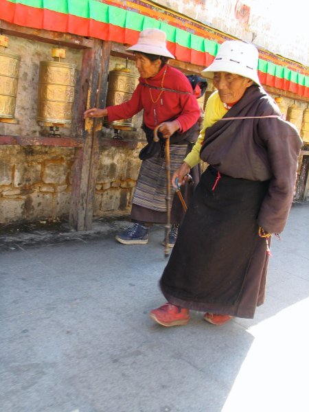 women turning prayer wheels at potala