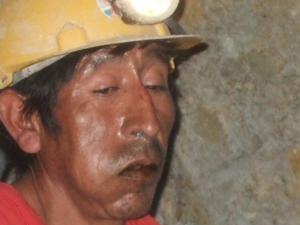 A lump of coca leaves are in the miner's right cheek