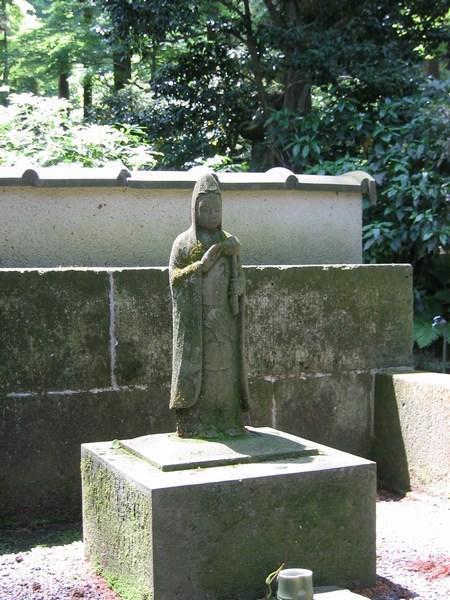 A beautifully carved stone figure atop a grave