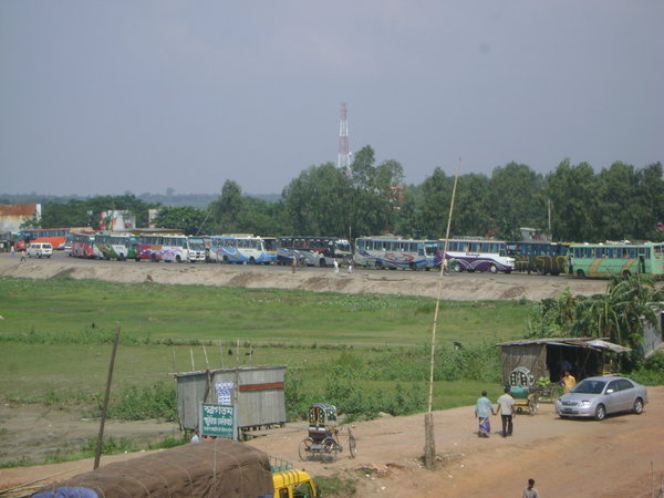 Buses waiting to go on a ferry that will carry them across a very big river