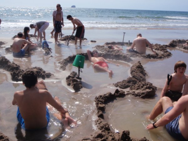 A beach shot showing everyone digging their holes