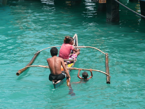 A family rows up to the jetty to beg, Tagbiliran, Bohol