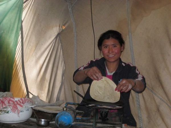 Young woman making us chapatti at around 16,000 ft