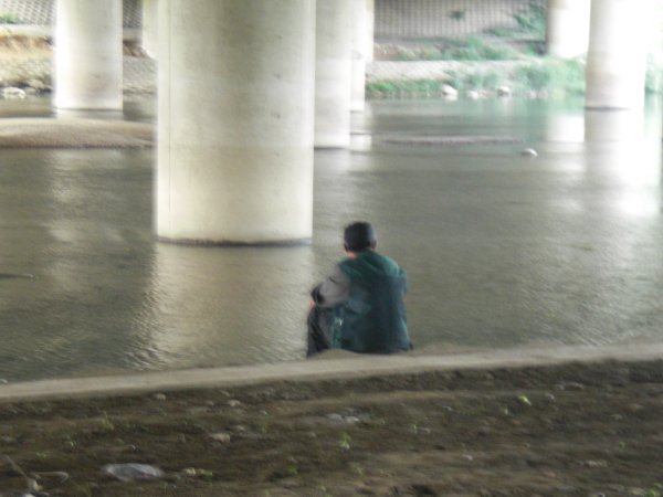 Man Sitting Under the Bridge