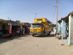 Truck driving through remote village in Sudan