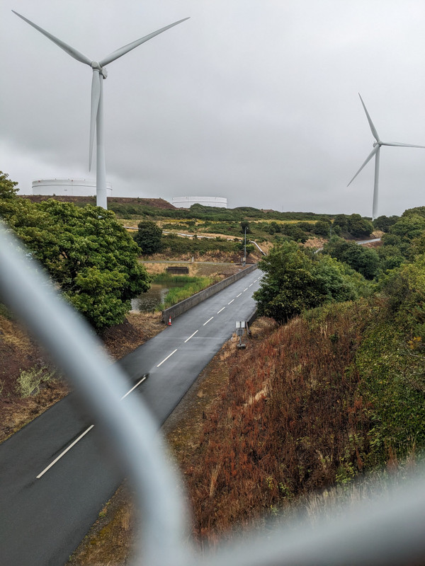 Windmills as seen through the overpass fencing 