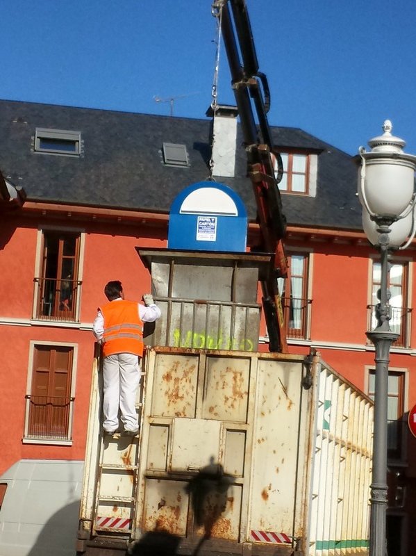 Underground trash receptacle being lifted onto garbage truck