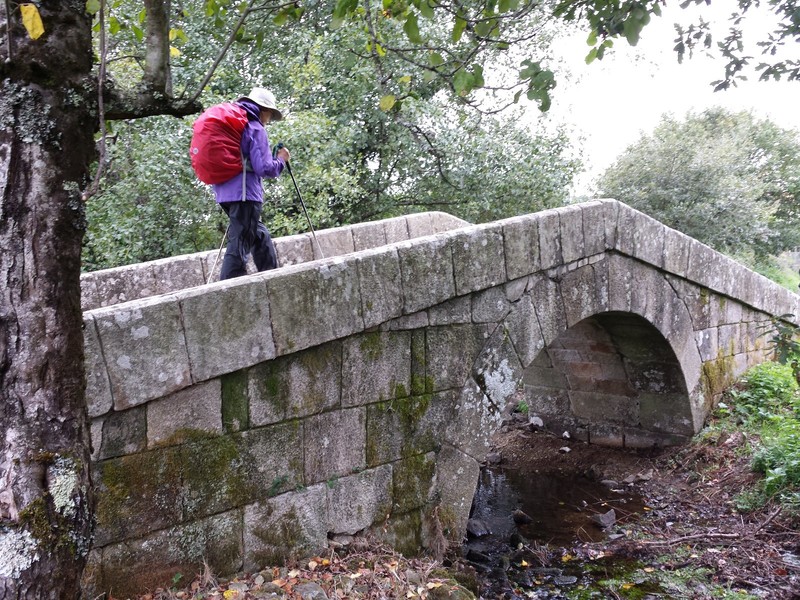 Karen crossing the stone bridge over river