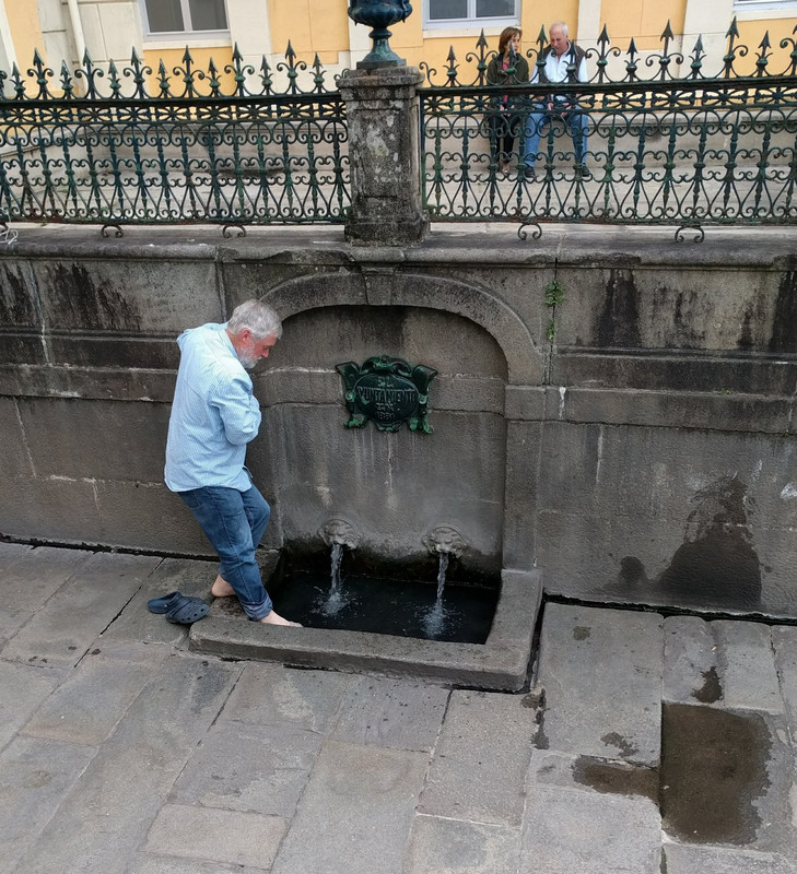 Julian tests the water in this hot spring fountain in Caldes de Reis
