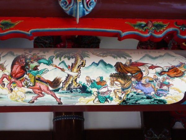 In de Guandi tempel tonen geschilderde taferelen de vechtlust van generaal Guan Yu die het postuum tot God van de Oorlog schopte.