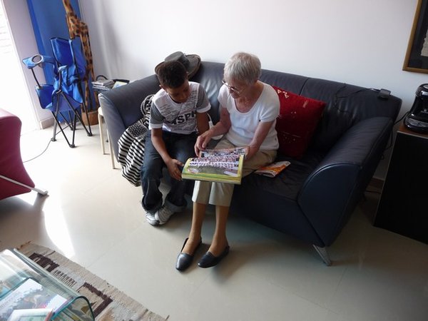 Oma en Anuar bekijken het fotoboek van Anuar's school.