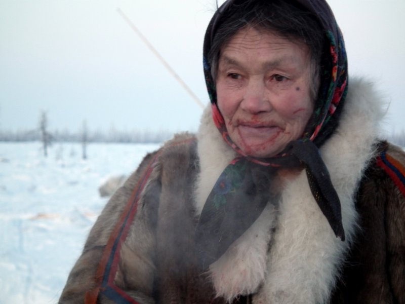 A Nenets woman after eating raw meat and drinking blood straight from a reindeer carcass (aibat), Nadym Region, Siberia