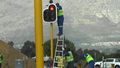 Road worker on top of a ladder maintaining the traffic light without a harness or any safety gear,O M G