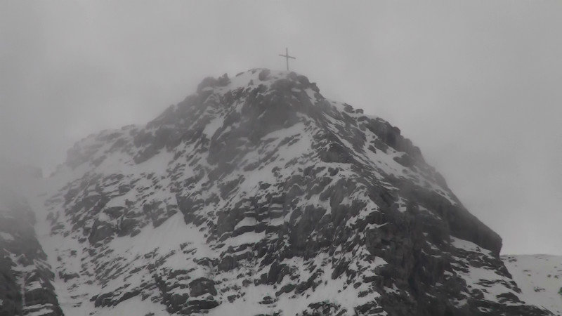 Cross on top of the mountain in the mist