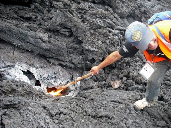 Our guide burning his walking stick in one of the 'vents' into the live lava