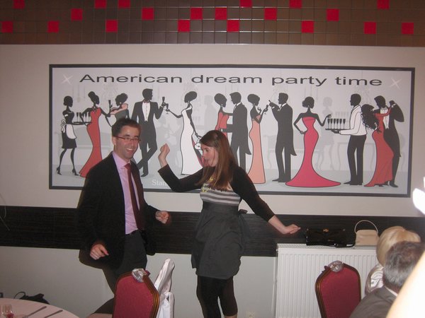 Dan and Chelsea cuttin' a rug under the "American Dream Party Time" sign