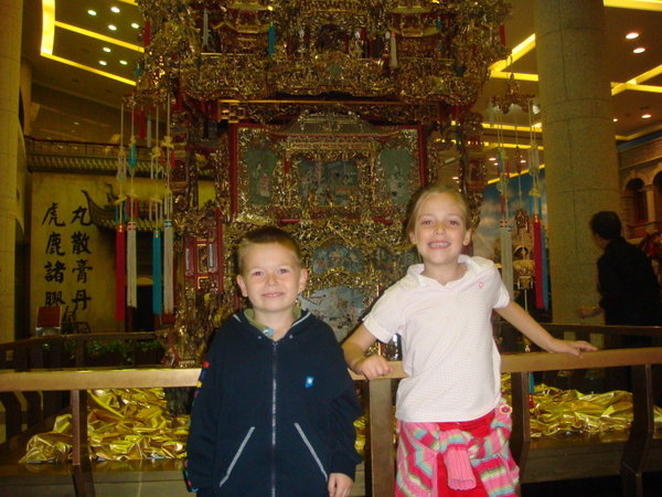 The kids with an old fashioned wedding sedan chair
