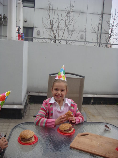 Sophie having bbq burger outside at Tiernan's party