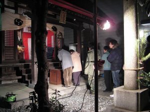 People pray for good fortune at small neighborhood shrine