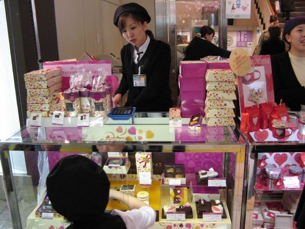 Shop assistant selling pralines boxes
