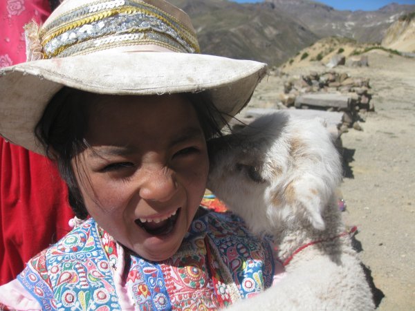 Young girl with young lama in Colca Canyon, Peru