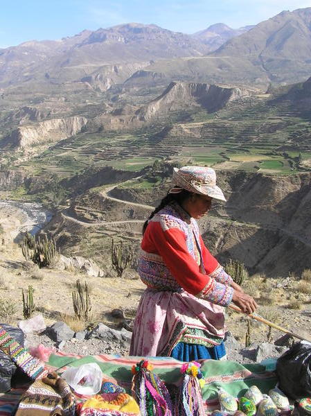 This lady is weaving at the side of the road, with an amazing backdrop