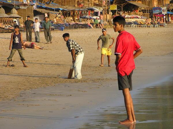 Indian lads playing cricket on the beach