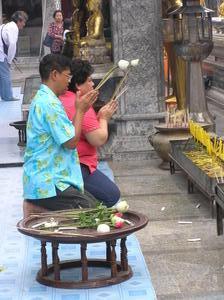 Thais offering a lotus, candle & incense to Buddha temple at Doi Suthep