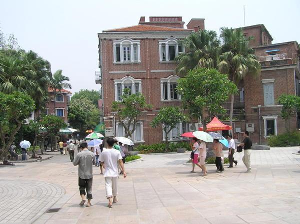 Colonial style square with chinese carrying parasols against the sun - GulangYu Island