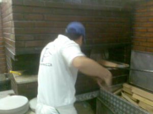 A chef tossing a pizza into the oven