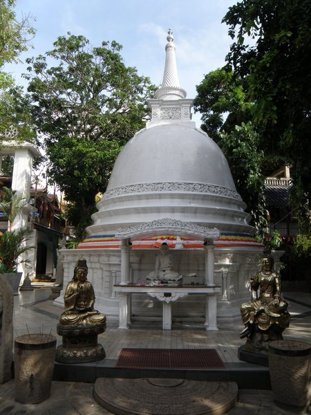 A stupa flanked by a pair of Chinese-style goddesses in Gangaramaya temple