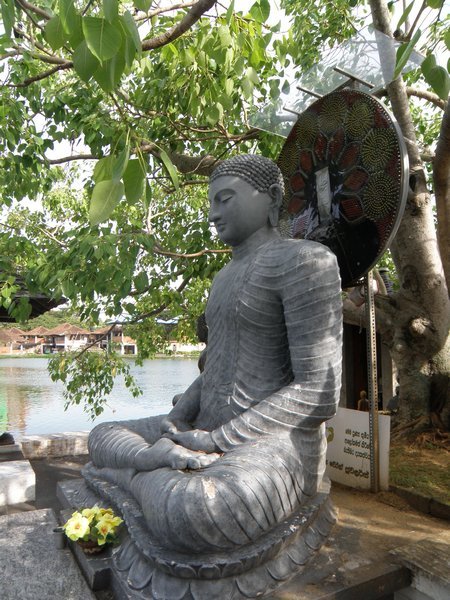 A statue of Buddha with a disc of LED lights behind its head