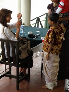 A tourist taking photo of a boy dressed in traditional clothes