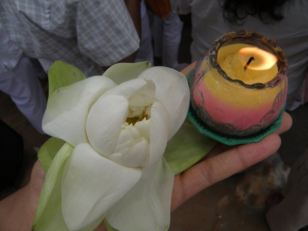 Me holding a lotus flower and a candle