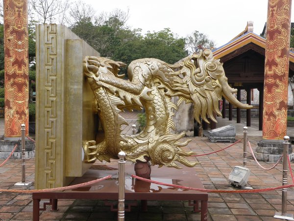 A sculpture of a dragon lifted 90Âº to show a Chinese phrase carved on the bottom