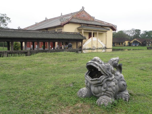 A stone lion with the Royal Theatre in the background