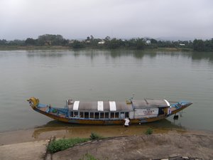 A tourist boat docking at the bank of the Perfume River