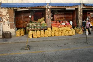 Small fruit market with sacks of oranges