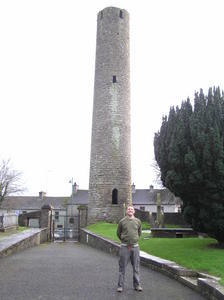 Sean in front of the Round Tower and a Celtic Cross