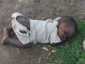 Village child asleep on the ground