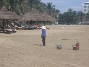 Vendors walk the sands carrying their pots of food