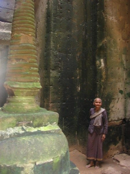 An elderly women stands inside the temple