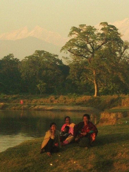 Local ladies stand by the river as the sun begins to fade