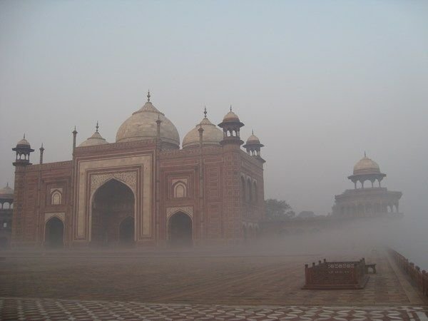 The fog rolls in toward the side structures of the Taj Mahal