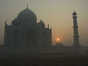 The sun rises behind the Taj